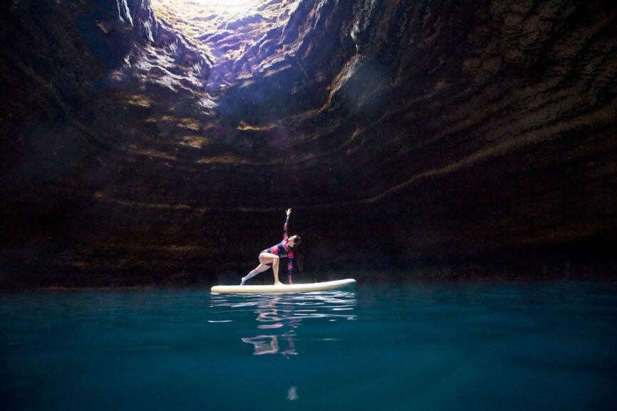 Woman doing yoga on the paddleboard in the Crater