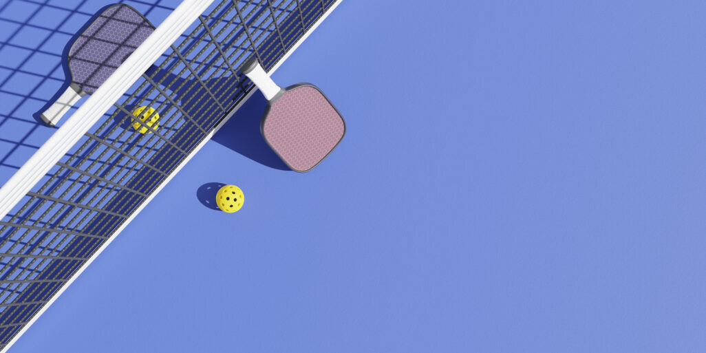 Rackets and balls for playing pickleball at the sports net on the court. 3D rendering