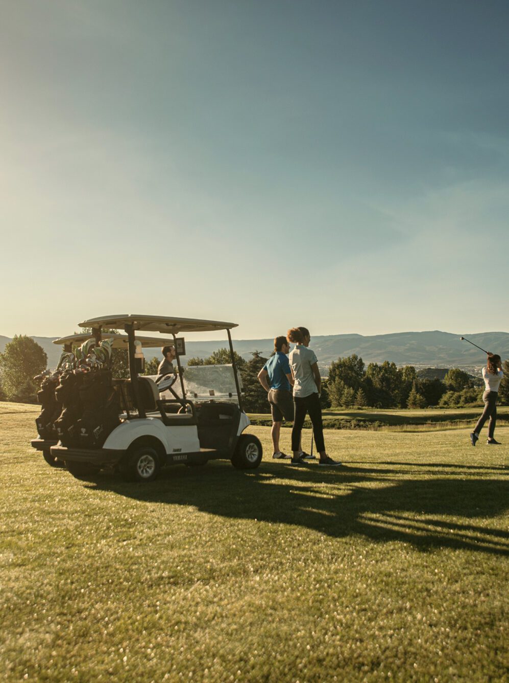 Group of golfers standing near the golf cart