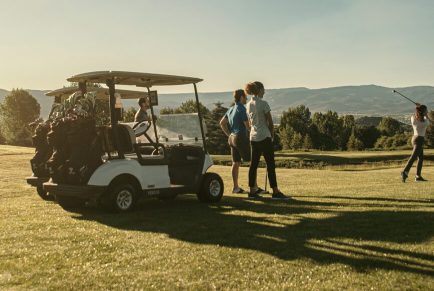 Group of golfers standing near the golf cart
