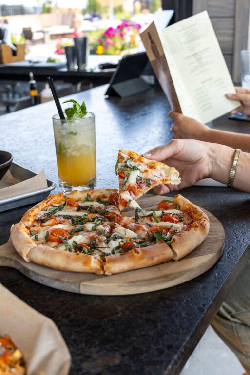 Hand taking the piece of pizza