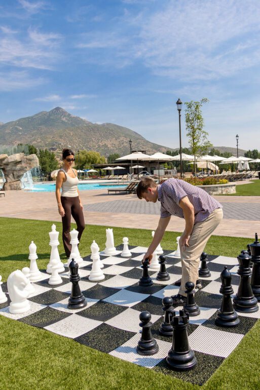 A couple playing giant chess outdoors