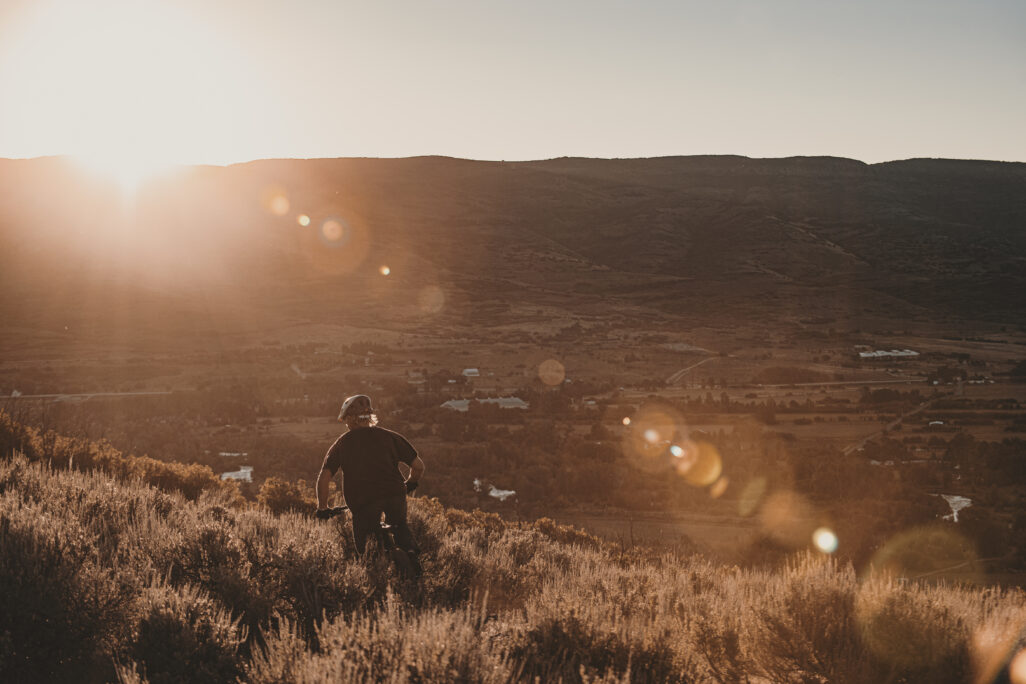 Person mountain biking in the sunset