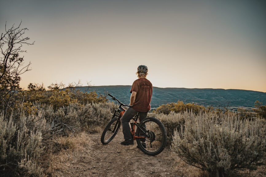 Person mountain biking in the sunset