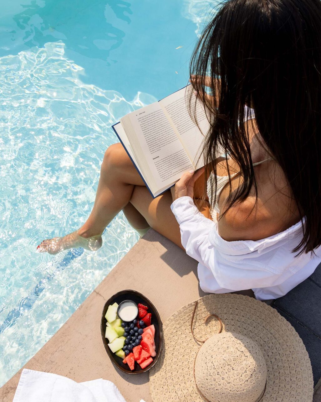 Person Reading Poolside at The Pools at Homestead